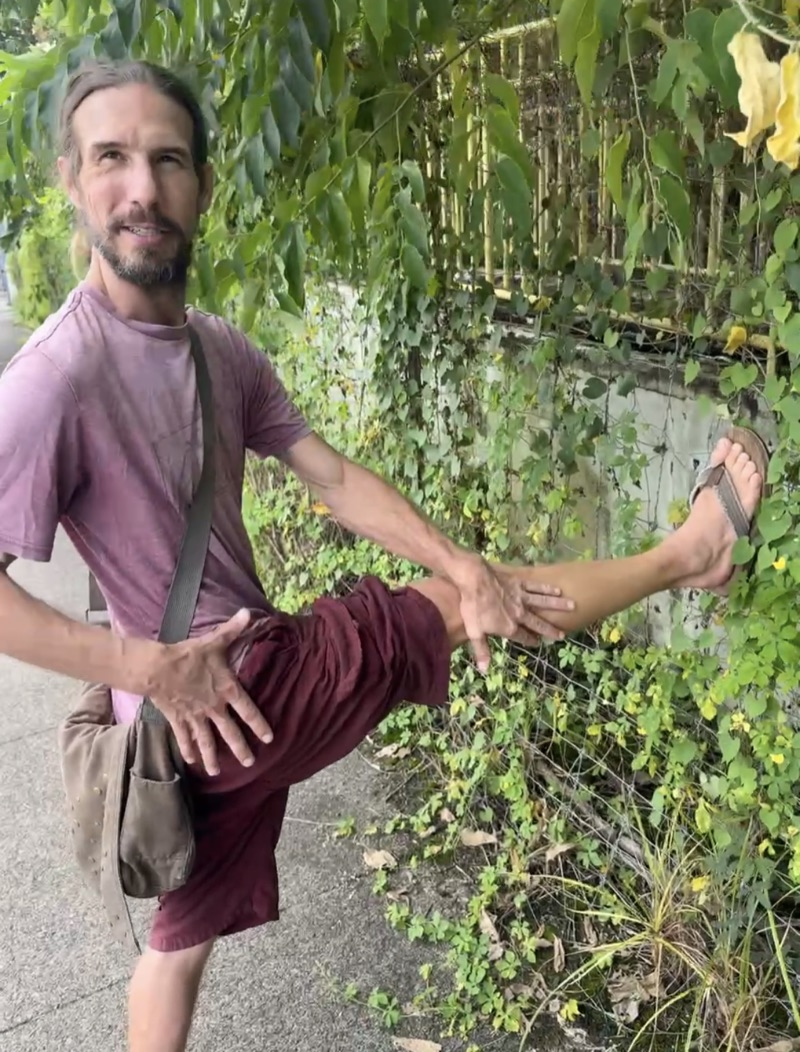 Xander demonstrating a standing stretch outdoors.